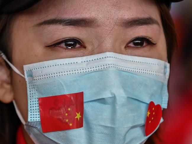 (FILES) In this file photo taken on April 08, 2020 A medical staff member from Jilin Province tears up during a ceremony before leaving as Tianhe Airport is reopened in Wuhan in China's central Hubei province on April 8, 2020. - the Guardian picture desk has chosen the AFP photojournalist Hector Retamal as agency photographer of the year 2020 for his coverage of the novel coronavirus Covid-19 pandemic in Wuhan, China. (Photo by Hector RETAMAL / AFP)