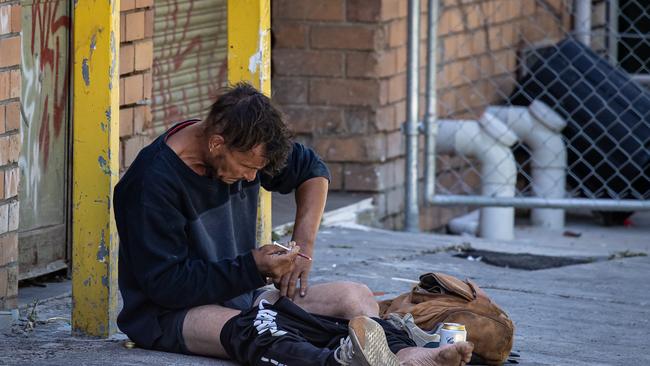 A man openly injects drugs into his leg in a thoroughfare alley just behind Victoria Street, Richmond. Picture: Jason Edwards