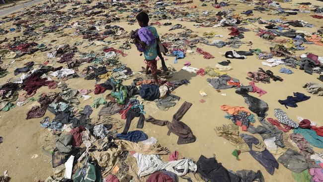 A Rohingya Muslim boy walks past discarded clothing on the ground at the Bhalukali refugee camp near Ukhia in 2017. According to the UN, nearly 400,000 Rohingya had arrived in Bangladesh in the previous month after fleeing a military crackdown launched by Myanmar's military. Picture: AFP Photo/Dominique Faget