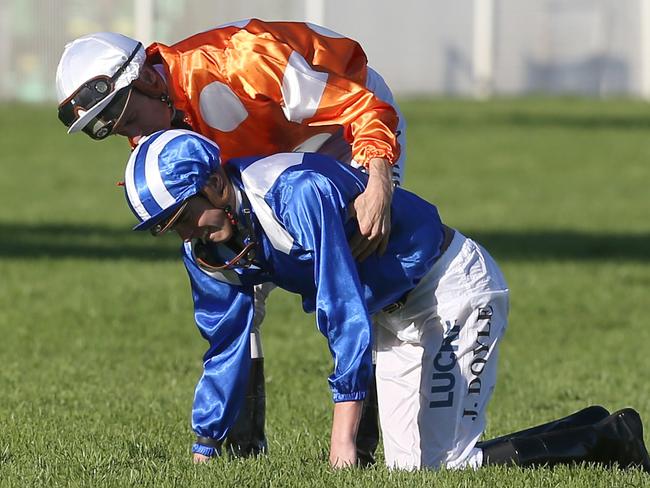 James Doyle helps Blake Shinn to his feet after they both fell during the Sydney Cup. Picture: Craig Golding