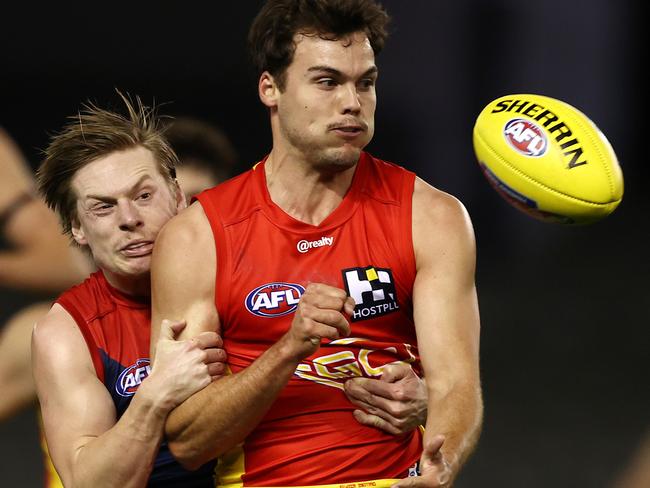 AFL Round 20. Gold Coast Suns v Melbourne at Marvel Stadium, Melbourne. 01/08/2021.  Jack Bowes of the Suns clears as he is tackled by Charlie Spargo of the Demons during the 1st qtr.     .  Pic: Michael Klein