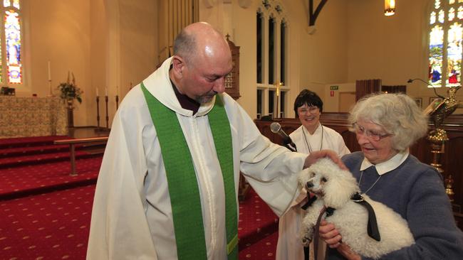 Fr Trickey blesses a dog for The Blessing of the Pets ceremony at Christ Church Geelong in 2013. Picture: Richard Serong