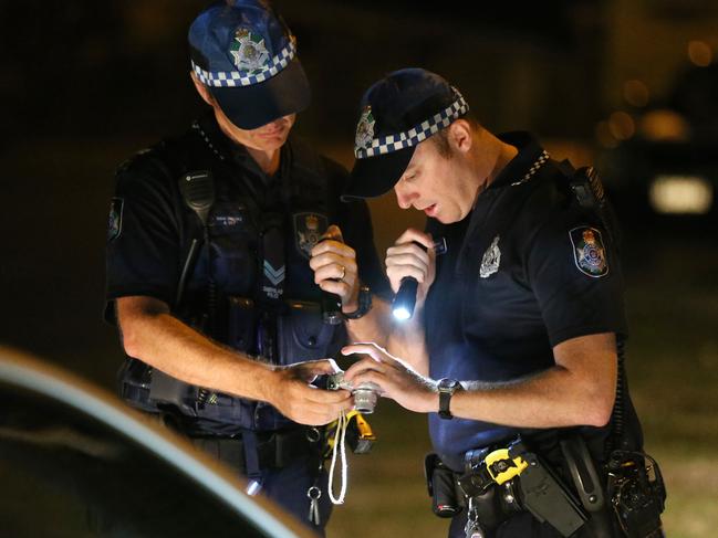 Police inspect bloody handprints on a car at the scene of a car surfing accident at Raintree Glen at Coombabah.  Picture Glenn Hampson