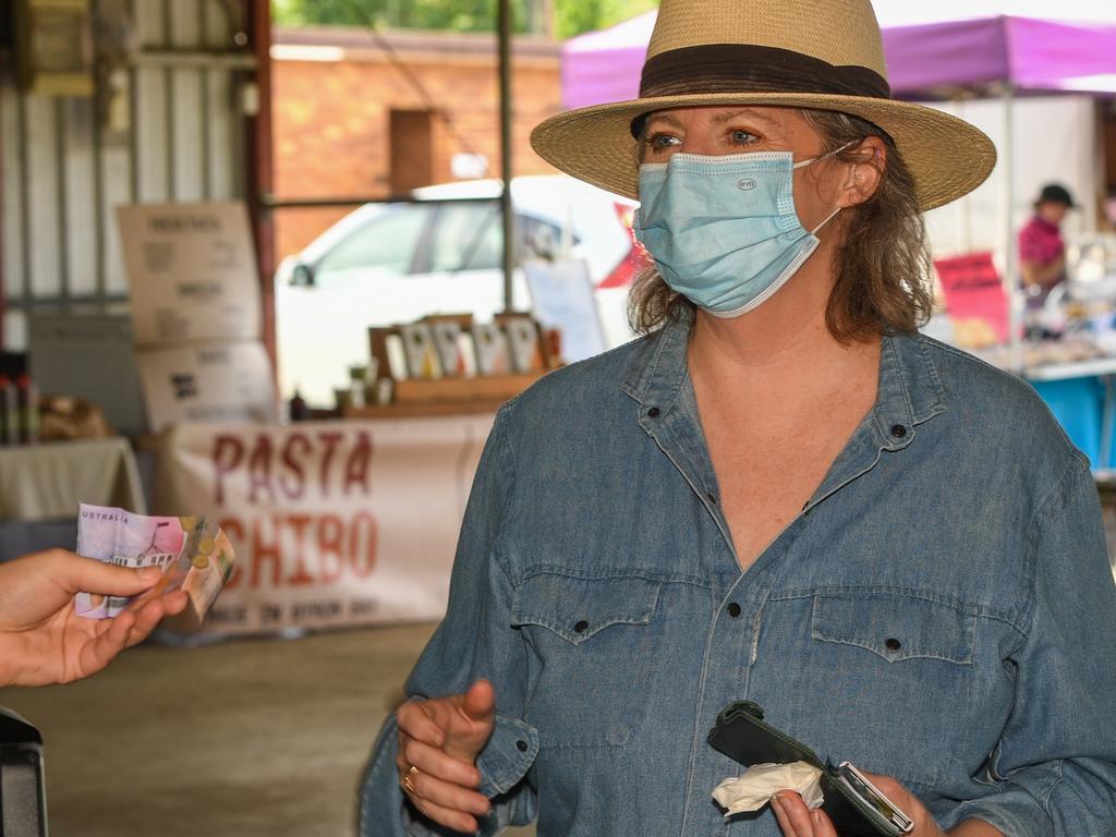 Libby Lincoln fetching a decadent donut from Bree Heatherington at the Lismore Farmers Markets.