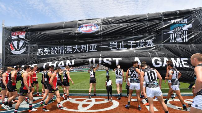 Players run through the banner during the 2019 China clash. Picture: AAP Image/David Mariuz