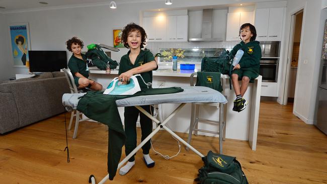 Brothers Mitchell Smith, 7, Toby, 9 and prep student Xavier, 5, get ready to go back to school. Picture: Nicki Connolly