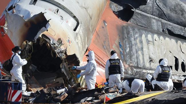 Police forensics personnel and National Bureau of Investigation officials work at the Muan scene. Picture: YONHAP/AFP