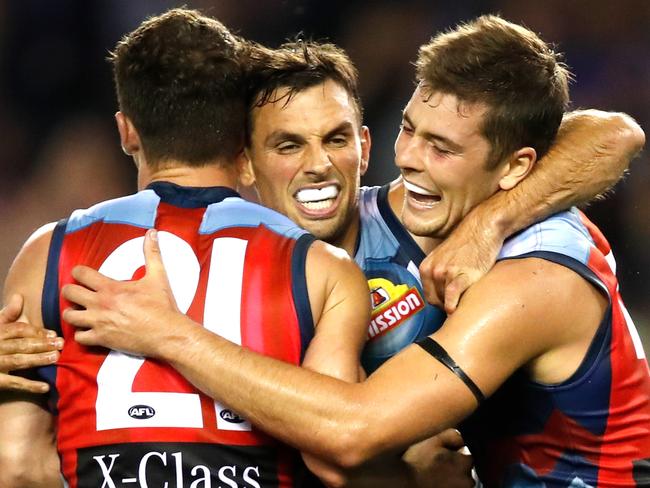 MELBOURNE, AUSTRALIA - MARCH 23: Sam Lloyd of the Bulldogs, Tom Liberatore of the Bulldogs & & Josh Dunkley of the Bulldogs celebrate a goal during the 2019 AFL round 01 match between the Western Bulldogs and the Sydney Swans at Marvel Stadium on March 23, 2019 in Melbourne, Australia. (Photo by Dylan Burns/AFL Photos)