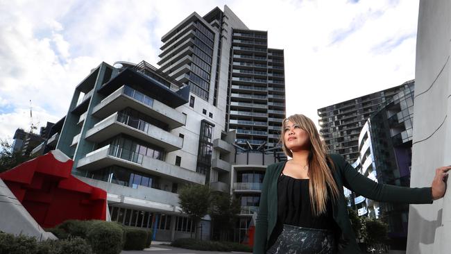 Real estate agent Mariecris Tagala near apartment buildings in Melbourne’s Docklands. Pic: David Geraghty