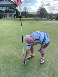 Rowan Braithwaite collects his ball after shooting a hole in one at the Gympie golf course on Tuesday.