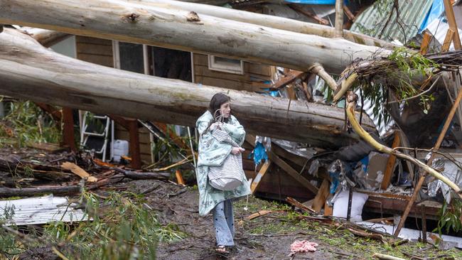 Alicia walks to her car with dry clothes after the house she and her mother were in was destroyed by a falling tree. Picture: David Geraghty