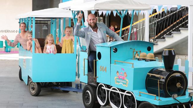 After many years of being missing in action, the Pacific Fair train is back for school holidays. Michelle Harris Smith and her daughters Grace Smith 6, Isley Smith 5 and Holly Smith 3, enjoying the train driven by Thomas McIntyre, Centre Concierge and part time driver. Picture Glenn Hampson