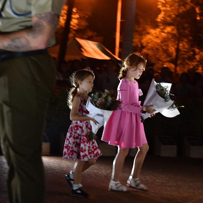 Young girls lay flowers at the service in Townsville. Picture: Evan Morgan