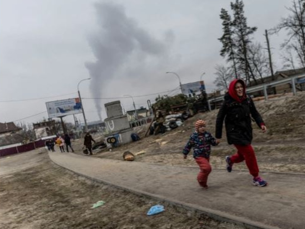 A woman and child flee from Russian attacks. Picture: Reuters