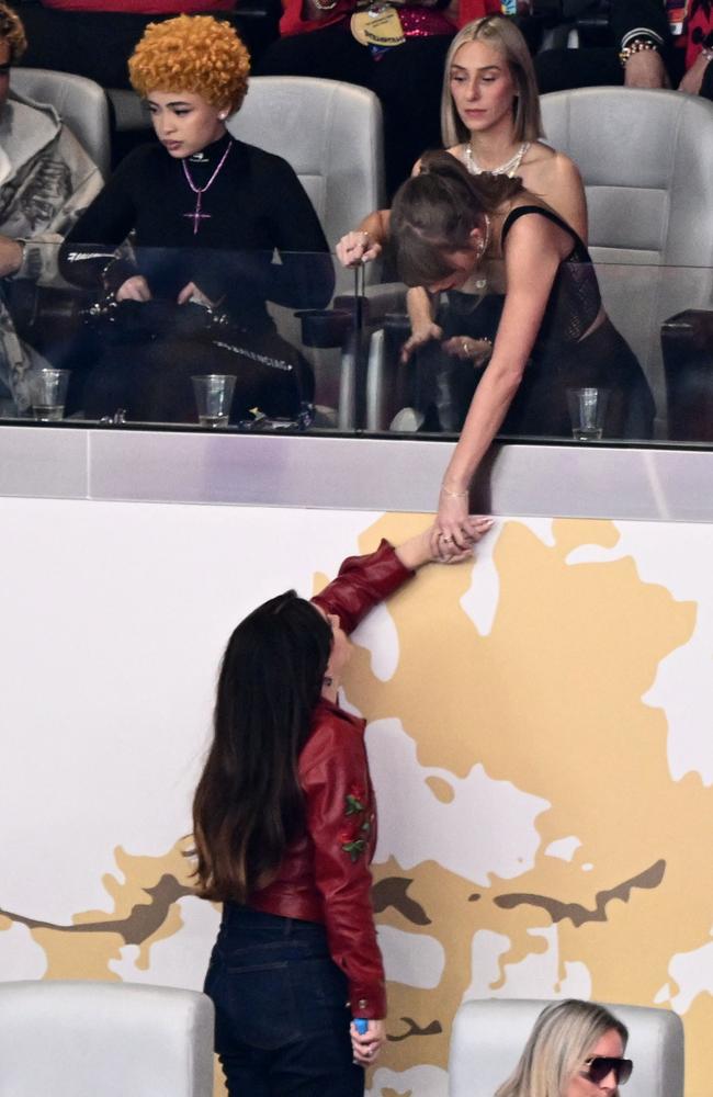 Lana Del Rey reaches up to greet Taylor Swift at the Super Bowl. Picture: AFP