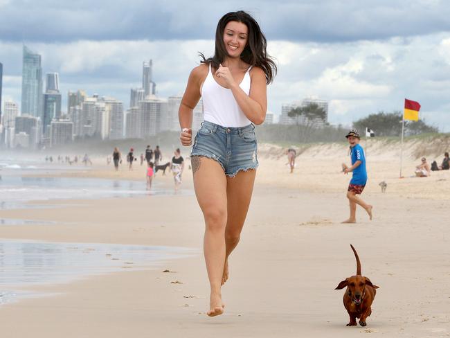 Brooke Chapman of Labrador pictured with her dog Delilah, a 2 year old Dacshund, making the most of the beach before the rain hits this week. Picture: Mike Batterham