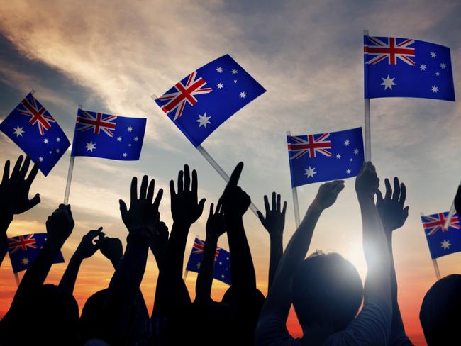 Group of People Waving Australian Flags in Back Lit