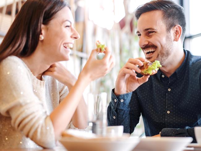 A young couple eating smashed avocado and other foods at breakfast in a cafe. Picture: iStock.