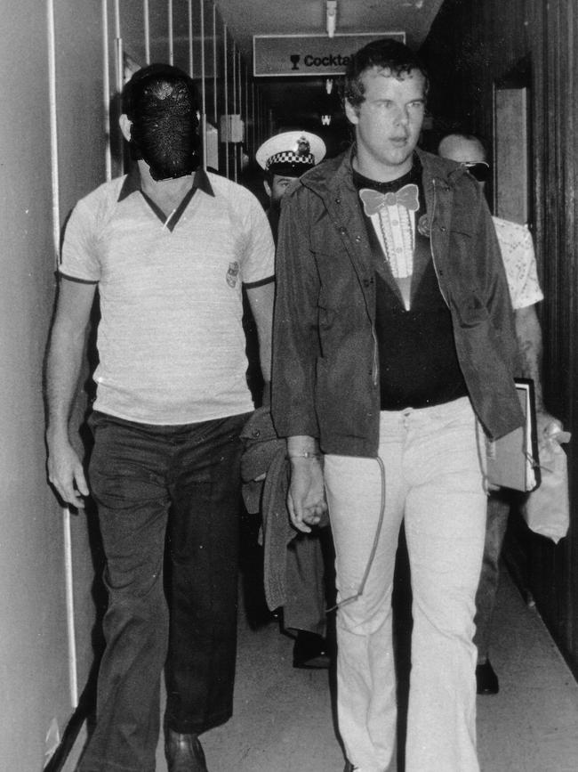 Murderer Andy Albury is led by detectives through the Darwin Airport. Albury was convicted of killing a woman in Darwin's Mitchell Street in November 1983 and mutilating her body. Circa: 8/1984.