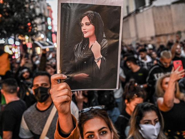 -- AFP PICTURES OF THE YEAR 2022 --  A protester holds a portrait of Mahsa Amini  during a demonstration in support of Amini, a young Iranian woman who died after being arrested in Tehran by the Islamic Republic's morality police, on Istiklal avenue in Istanbul on September 20, 2022. - Amini, 22, was on a visit with her family to the Iranian capital when she was detained on September 13 by the police unit responsible for enforcing Iran's strict dress code for women, including the wearing of the headscarf in public. She was declared dead on September 16 by state television after having spent three days in a coma. (Photo by Ozan KOSE / AFP) / AFP PICTURES OF THE YEAR 2022