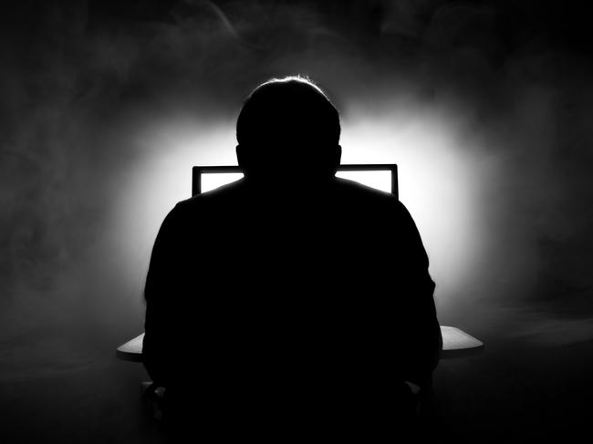 Man in front of computer. Dark night room with smoke. Man on computer. Sillhouette. Internet dating. From behind. iStock-862022082.jpg Photo: iStock