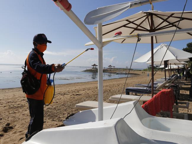 An official sprays disinfectant to prevent the new coronavirus at a beach in Bali. Picture: AP