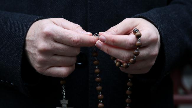 A supporter of the church was seen holding their rosary beads ahead of Cardinal Pell’s appeal hearing. Picture: Michael Dodge/Getty