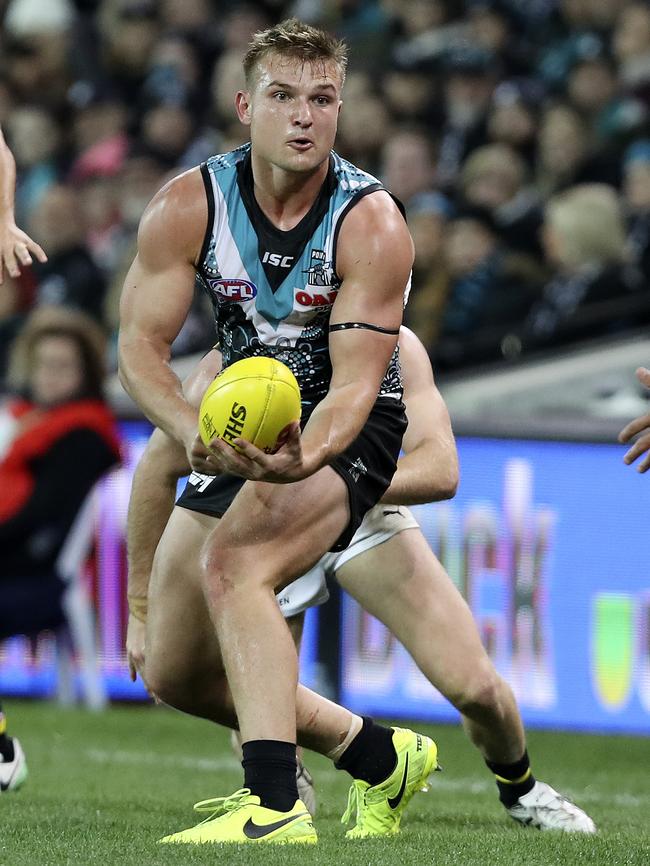 Injured star Ollie Wines fires out a handpass against Richmond in 2018.