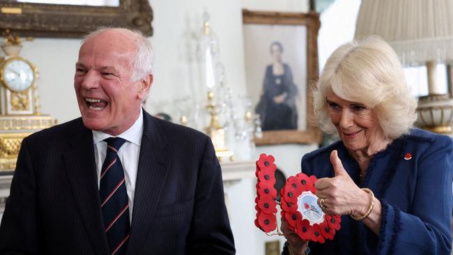 Queen Camilla gives the thumbs up to guests after successfully cutting the cake. Picture: AFP