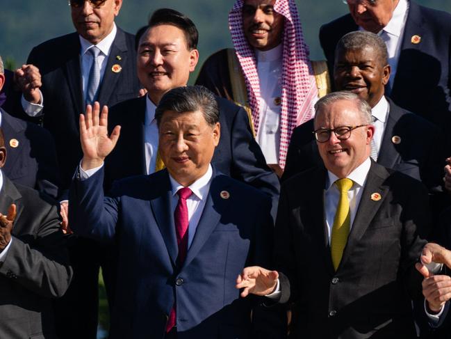 Chinese President Xi Jinping (C) gestures as he stands alongside Australian Prime Minister Anthony Alabanese (R) during a group photo with G20 leaders at the G20 Summit in Rio de Janeiro, Brazil, on November 18, 2024. (Photo by ERIC LEE / POOL / AFP)