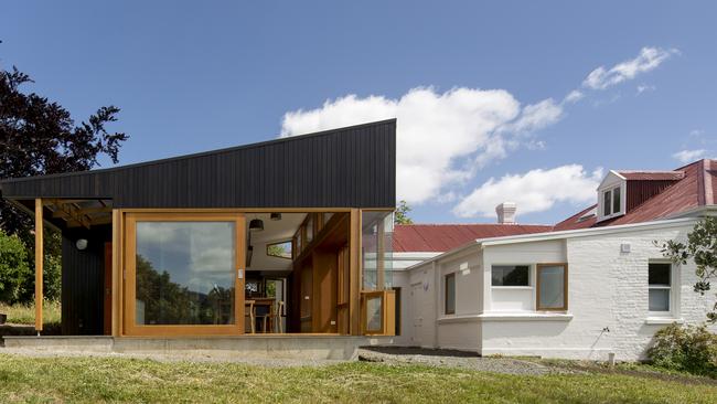 The beautiful modern extension which has been decked out with dark-stained locally sourced exterior hardwood used to evoke the spirit of the “Tassie shack”. Picture: BRETT BOARDMAN