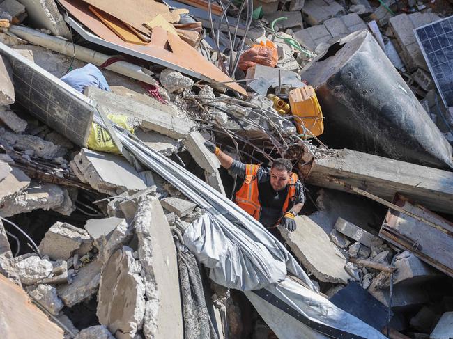 A rescuer searches for casualties in the rubble of a house destroyed in an Israeli strike on al-Jalaa street in central Gaza City. Picture: AFP