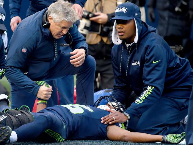 SEATTLE, WA - DECEMBER 24: Head coach Pete Carroll of the Seattle Seahawks tends to wide receiver Tyler Lockett #16 after he was injured in a play against the Arizona Cardinals at CenturyLink Field on December 24, 2016 in Seattle, Washington. Steve Dykes/Getty Images/AFP == FOR NEWSPAPERS, INTERNET, TELCOS & TELEVISION USE ONLY ==