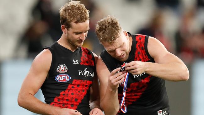 Darcy Parish shows off his Anzac Day medal to teammate Jake Stringer. Picture: Michael Willson/AFL Photos via Getty Images