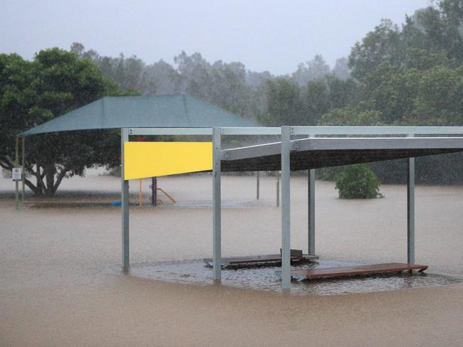 A Gold Coast City Council BBQ facility on Casuarina Drive Elanora disappears under quickly rising flood waters broke the bank of Lakewoods Lake due to heavy rainfall which fell over the Gold Coast. Picture: NCA NewsWire / Scott Powick