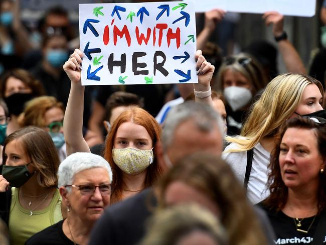 People hold up placards during a "March 4 Justice" rally against sexual violence and gender inequality in Melbourne on February 27, 2022. (Photo by William WEST / AFP)