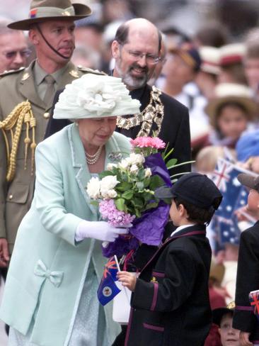 Queen Elizabeth II accepts flowers from young schoolboys in 2000.