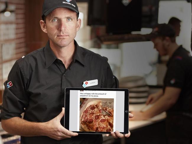 Domino's multi-unit franchisee Leroy Day holds a laptop with a Facebook comment derogatory about the pepperoni on a pizza order. Picture: Domino's