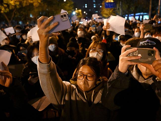 Protesters march along a street in Beijing. Picture: Noel Celis/AFP