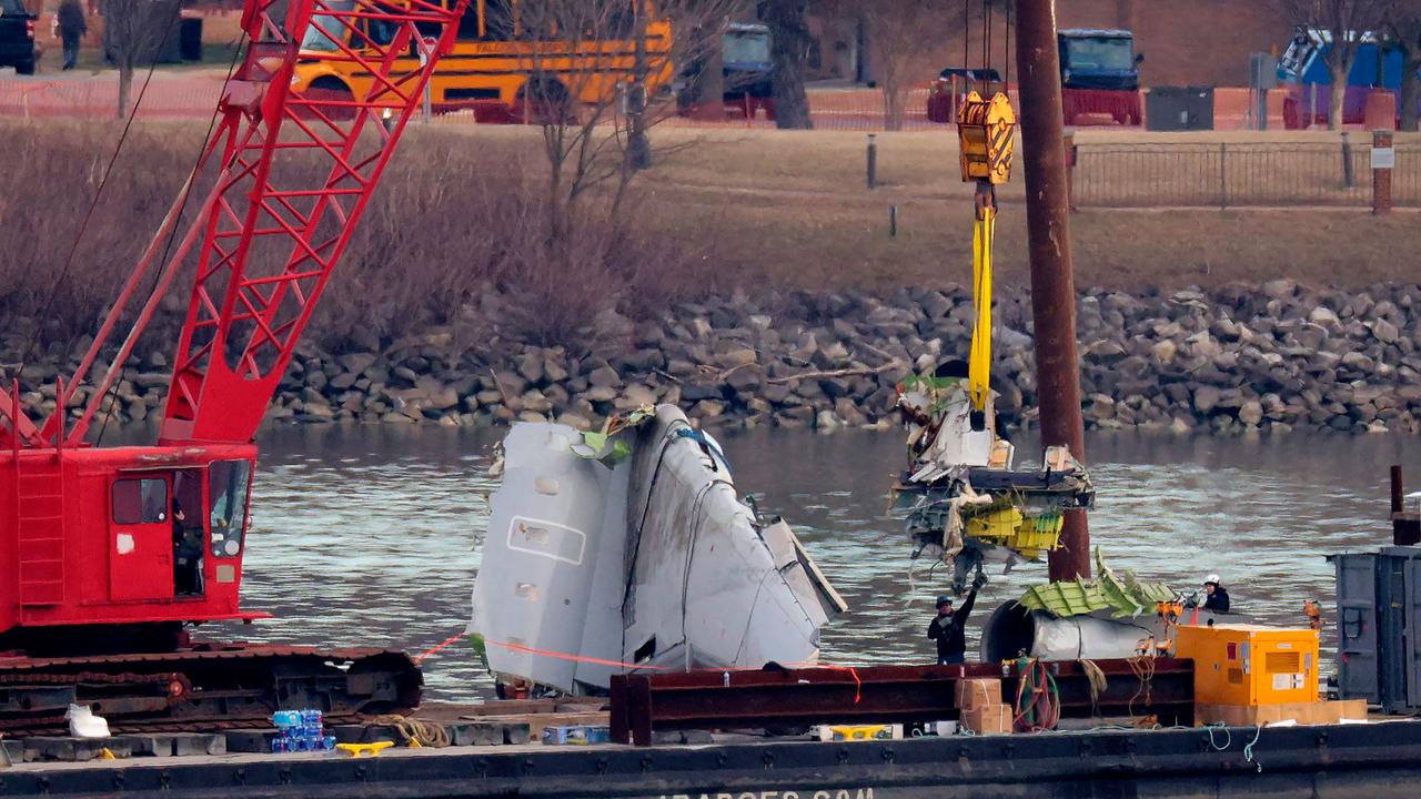 A salvage worker guides a piece of American Airlines flight 5342 as a crane lowers it next to an engine and wing that were also removed from the Potomac River. Picture: Chip Somodevilla/Getty Images via AFP