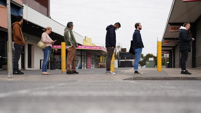 People are seen queuing outside a Centrelink office in Preston, Melbourne.