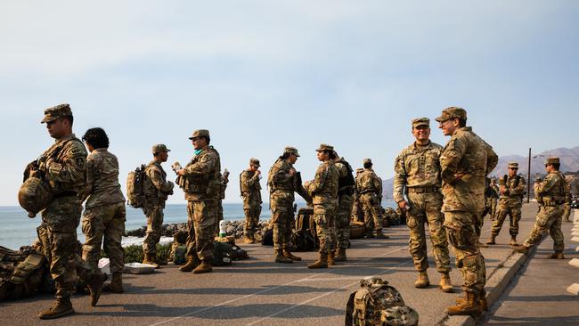 Members of the Army National Guard eat lunch along Pacific Coast Highway while on deployment to assist with various fires in Los Angeles. Picture: AFP