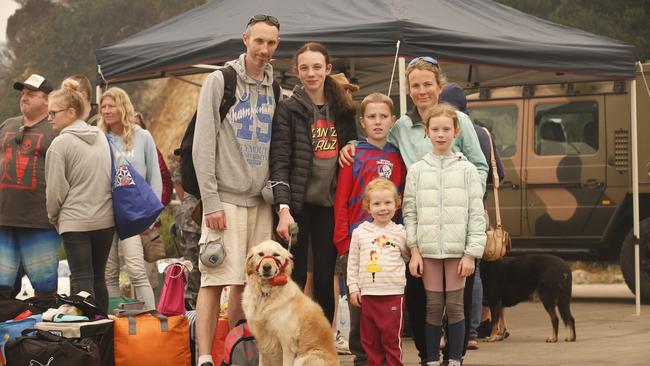 Damien Koster and wife Elly with their children, Bethany, 14, Tyler 12, Katie 3, Isabella, 8, and dog Sloane wait to board the boats at Mallacoota. Picture: David Caird