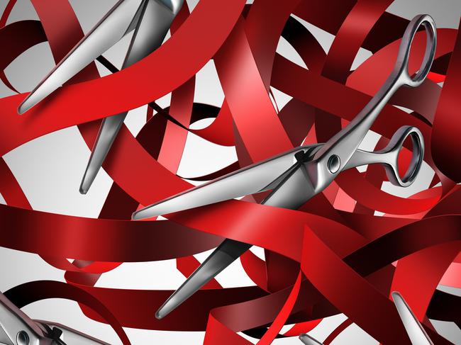 Cutting red tape and bureaucracy obstacle business concept as a group of scissors making cuts to symbols of government gridlock and regulatory confusion.