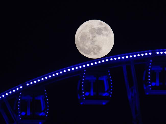 A “supermoon” is seen rising beyond a ferris wheel in Hong Kong on November 14, 2016. Picture: AFP PHOTO / ANTHONY WALLACE