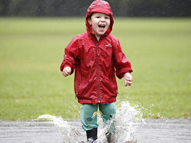 Otto Grenville, 3, playing in puddles during today's horrible weather in Tunks Park Cammeray on the 14th of March. Rainy and windy weather is forcast to stay in Sydney all week. Picture: Adam Yip