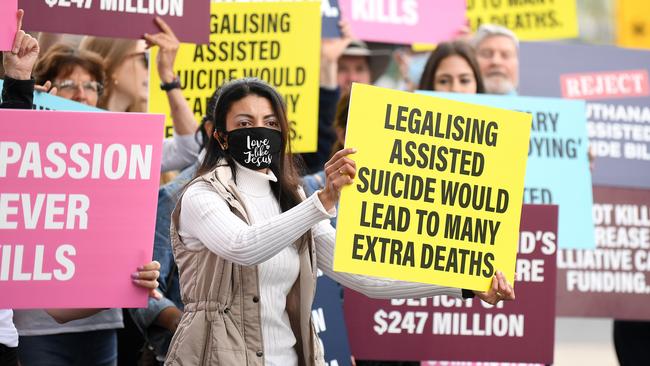 Anti-euthanasia protesters hold signs outside Parliament House in Brisbane. Picture: Dan Peled