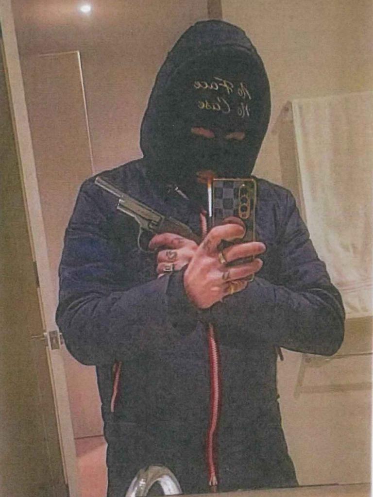 Evidence found on Alex Urquhart's phone included a photo of the trafficker posing in a balaclava with a stolen firearm. The balaclava read "no face, no case" but Urquhart was identified using tattoos on his hands. Picture released by the County Court of Victoria.