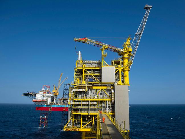 (FILES) In this file photo taken on April 8, 2019 employees walk along the Total Culzean platform on the North Sea, about 45 miles (70 kilometres) east of the Aberdeen, Europe's self-proclaimed oil capital on Scotland's northeast coast. - Following the energy shock from the war in Ukraine, the UK government will on April 7, 2022 outline a much-delayed energy strategy that will call for more renewable power from nuclear, wind and solar. But it will also likely give a controversial nod to more drilling for North Sea oil and gas, and the government is looking too into lifting a ban on fracking for shale gas on land. (Photo by Andy Buchanan / AFP) / TO GO WITH AFP STORY by Joseph SOTINEL