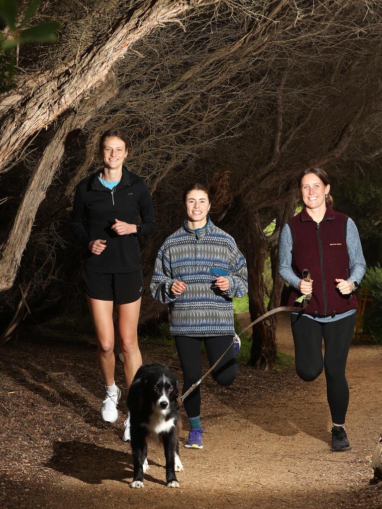 Torquay Run Club women’s and LQBTQIA+ night jog members Emily Cerini, left, Katelyn Dooley and Eliza Nolan with Harper the dog. Picture: Alison Wynd